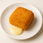 Fondue 5 fromages panée croustillante avec fromage fondant qui coule sur une assiette blanche.